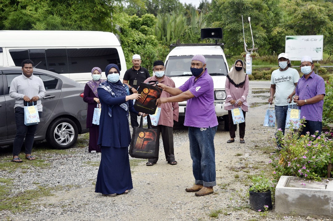Pegawai Penerangan Daerah Kuala Terengganu, Ros Naini Arshad menyampaikan juadah berbuka puasa kepada wakil penduduk, Hanafiah Ismail.